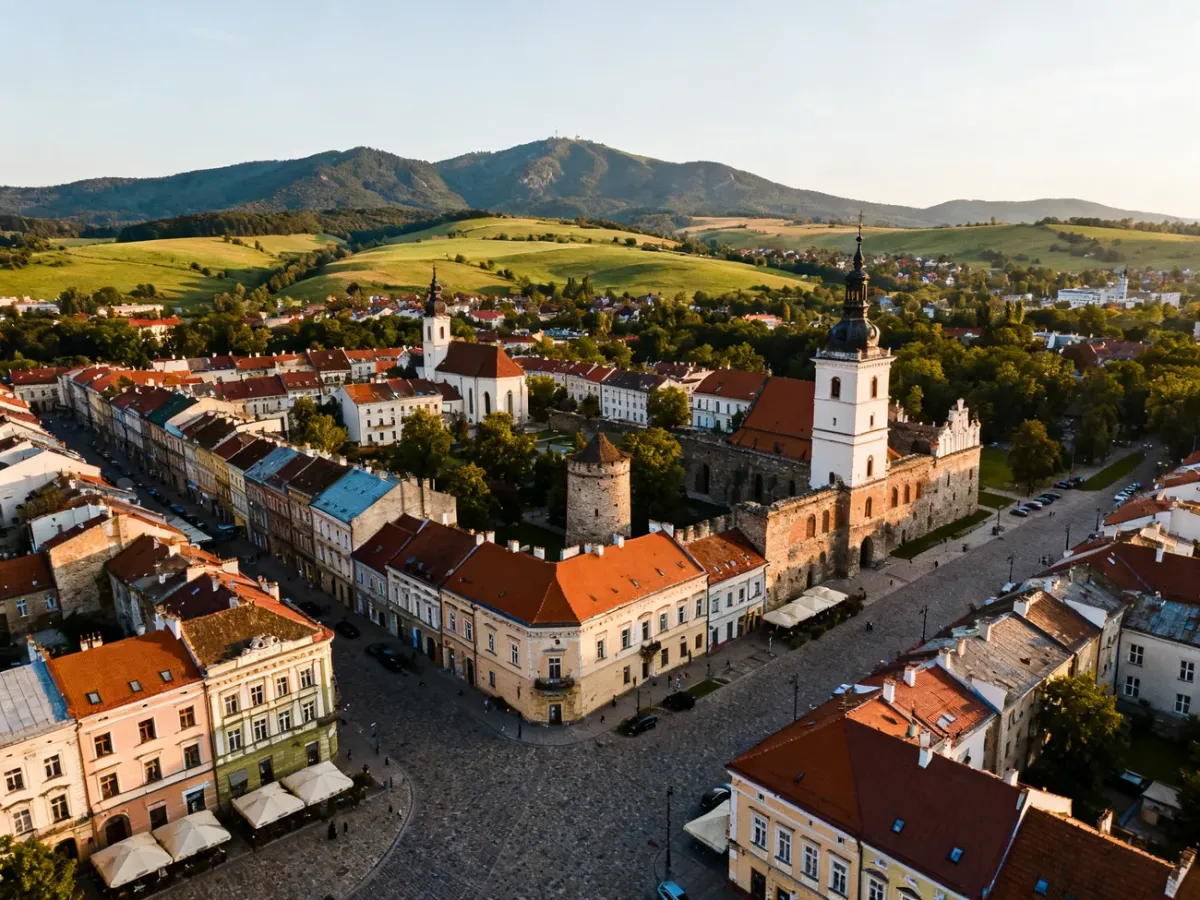Panorama Kielc z historycznym centrum i zielonymi wzgórzami w tle