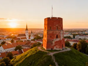 Panoramiczny widok na zabytkową twierdzę Alcazaba w Maladze, otoczoną kwitnącymi bugenwillami i błękitem Morza Śródziemnego.
