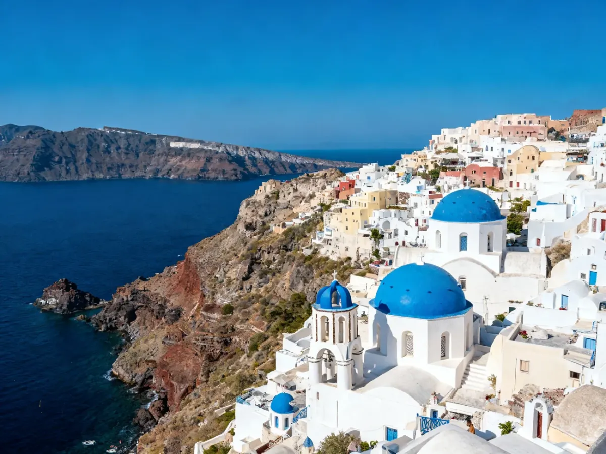 Panorama kaldery Santorini z białymi domami i niebieskimi kopułami
