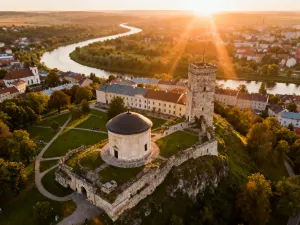 Biały meczet Sidi Jmour na tle piaszczystych wydm i turkusowego morza na wyspie Djerba w świetle zachodzącego słońca.