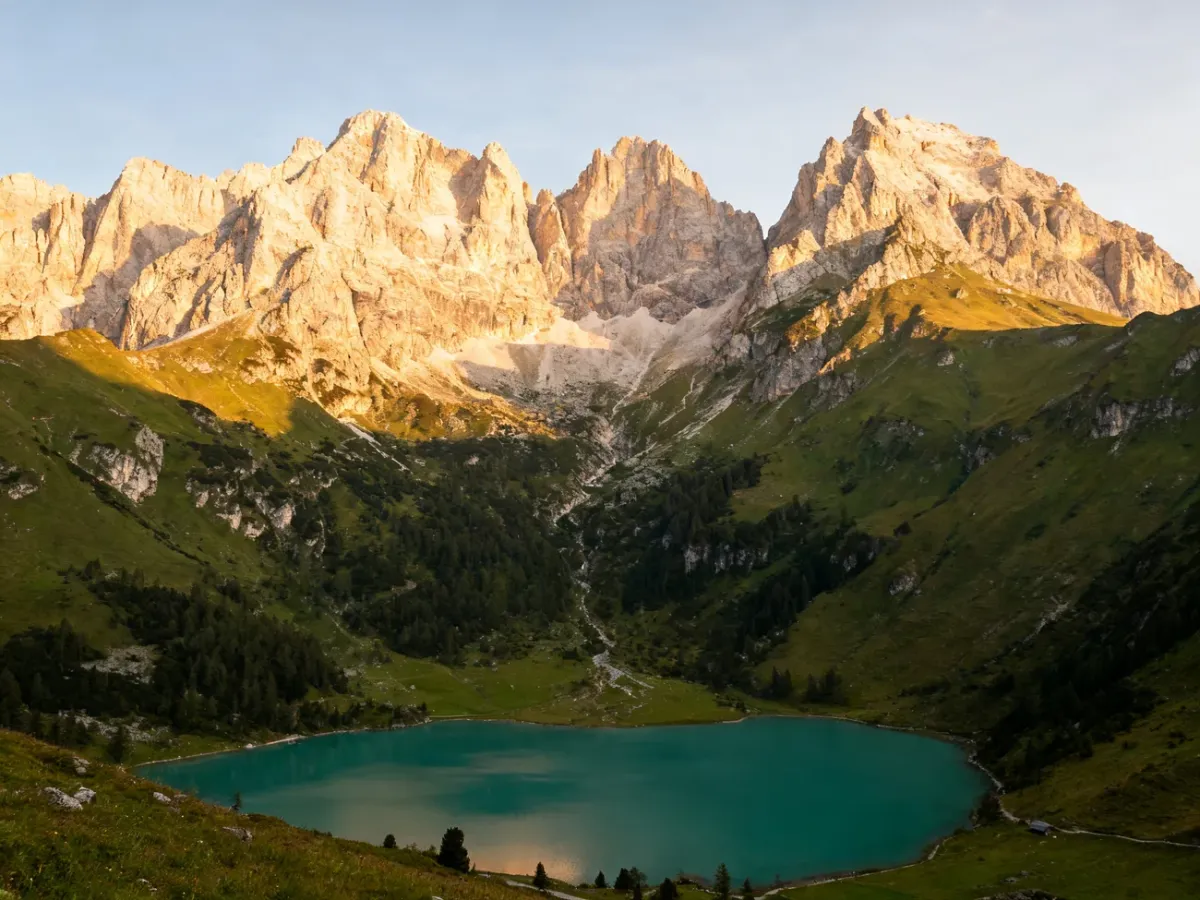 Panoramic view of the Dolomites with limestone peaks, green valleys, and an alpine lake