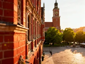 Widok na most Dom Luís I i kolorowe łodzie Rabelo na rzece Douro w Porto podczas zachodu słońca.
