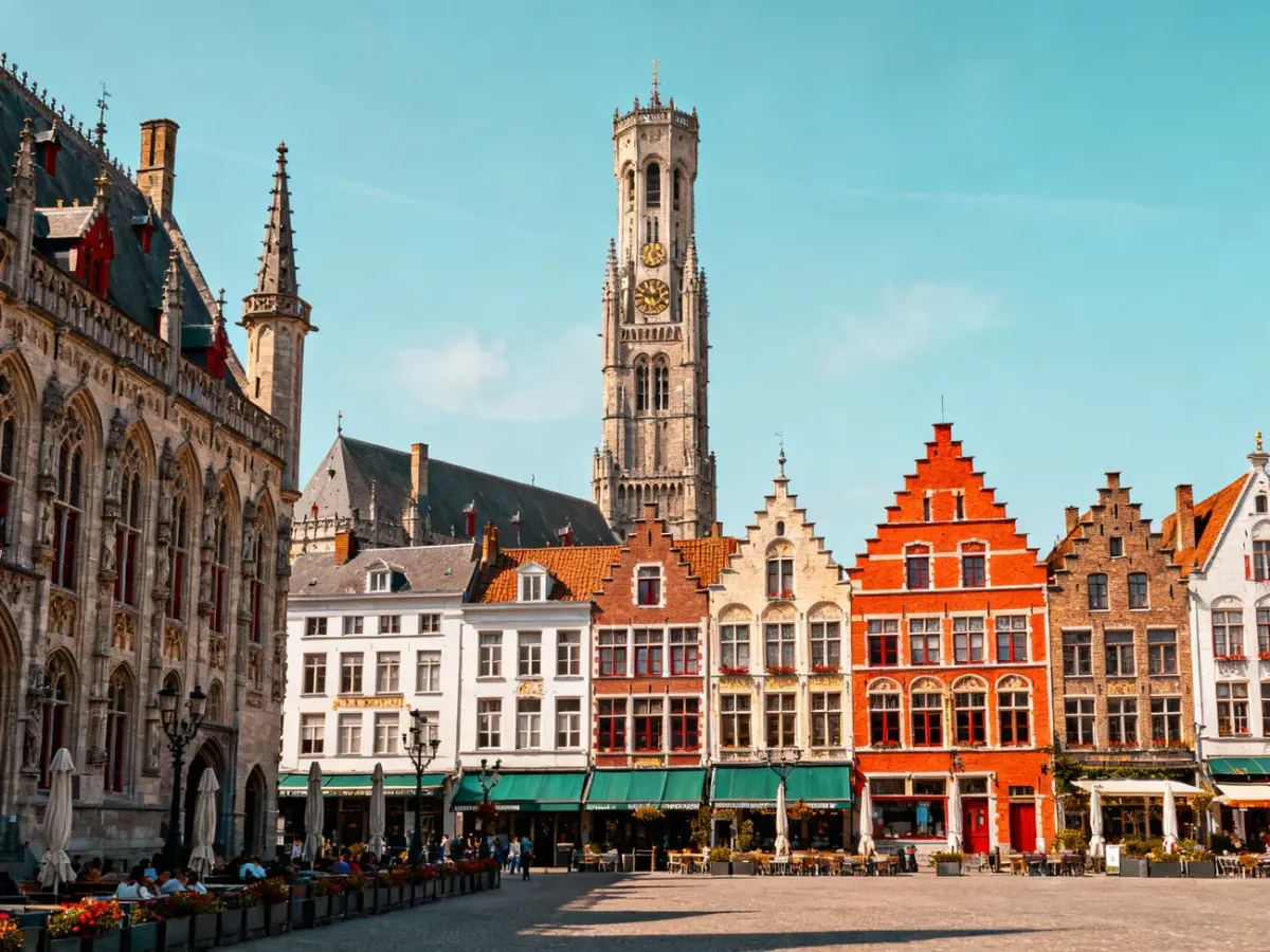 Zabytkowy rynek Markt w Brugii z kolorowymi kamienicami i wieżą Belfort