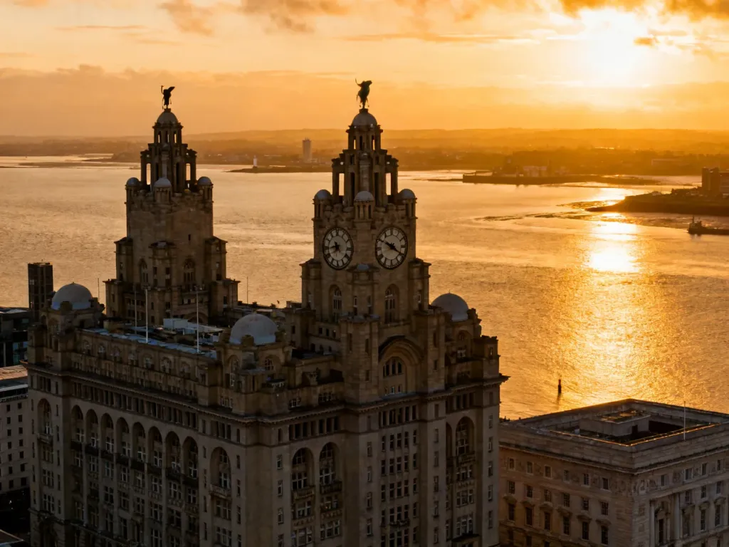 Panoramiczny widok na nabrzeże Liverpoolu z budynkiem Royal Liver Building o zachodzie słońca.
